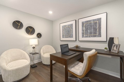 a home office with two chairs and a desk with a laptop